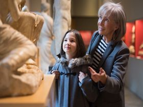 A senior woman and a young girl admiring a sculpture